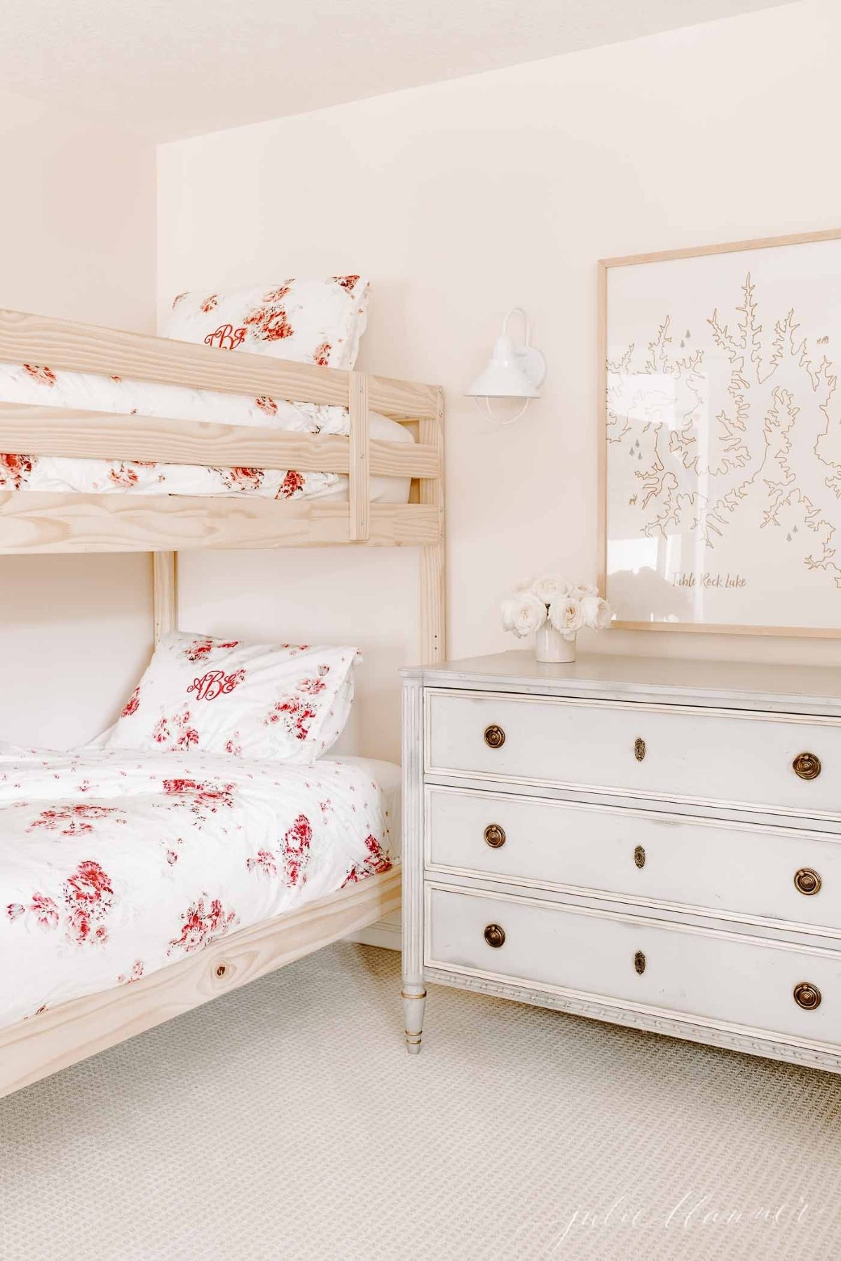 Girls bunk beds with floral bedding in a pink bedroom.