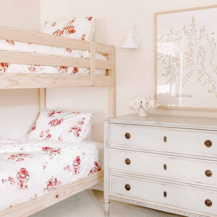 Girls bunk beds with floral bedding in a pink bedroom.