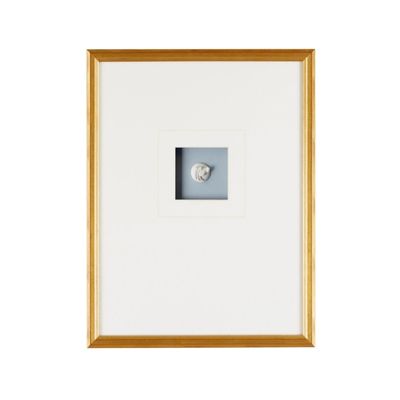 A gold framed intaglio with a large white mat.