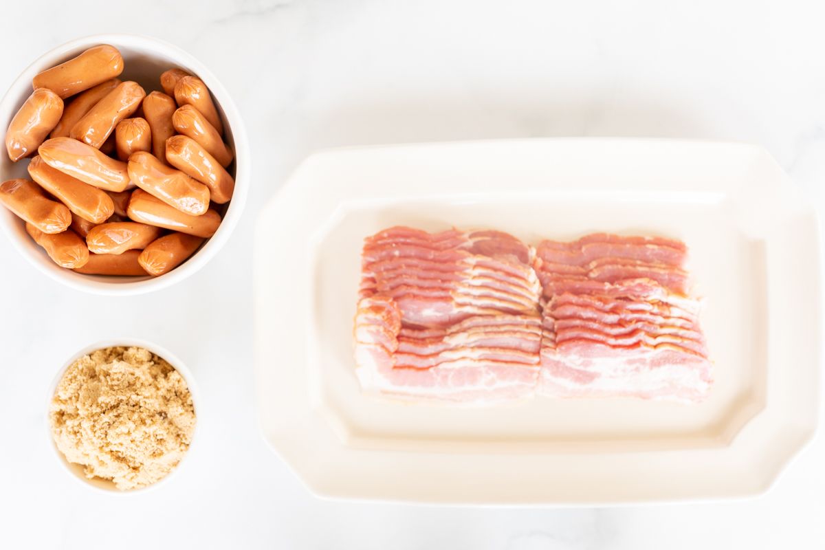Ingredients for bacon wrapped little smokies, laid out on a white countertop. 