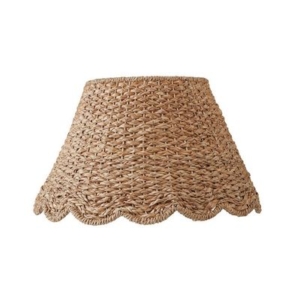 A wicker lamp shade with scalloped decor.