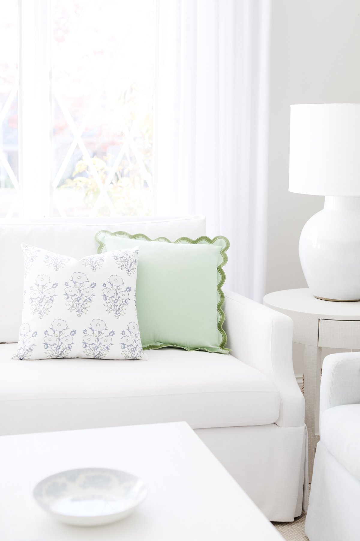 A white couch with scalloped decor in a living room.