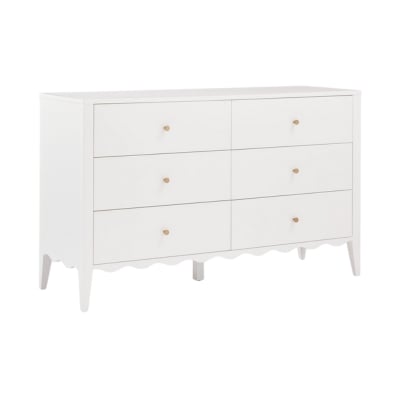 A white dresser with gold handles and scalloped decor.