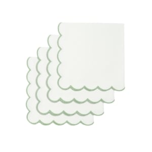 A set of white napkins with green trim and scalloped decor.