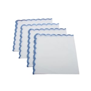 Four scalloped decor napkins on a white surface.