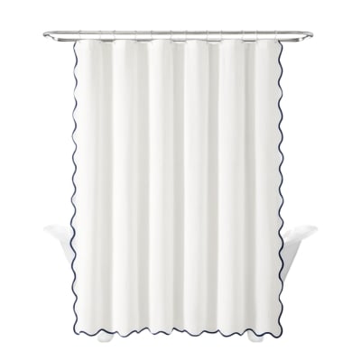 A white shower curtain with blue, scalloped trim.