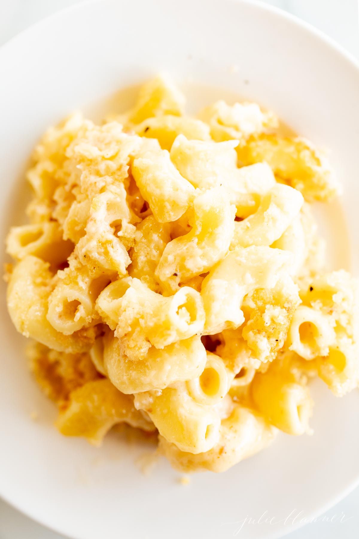 baked mac and cheese on a white plate as a side dish for chicken