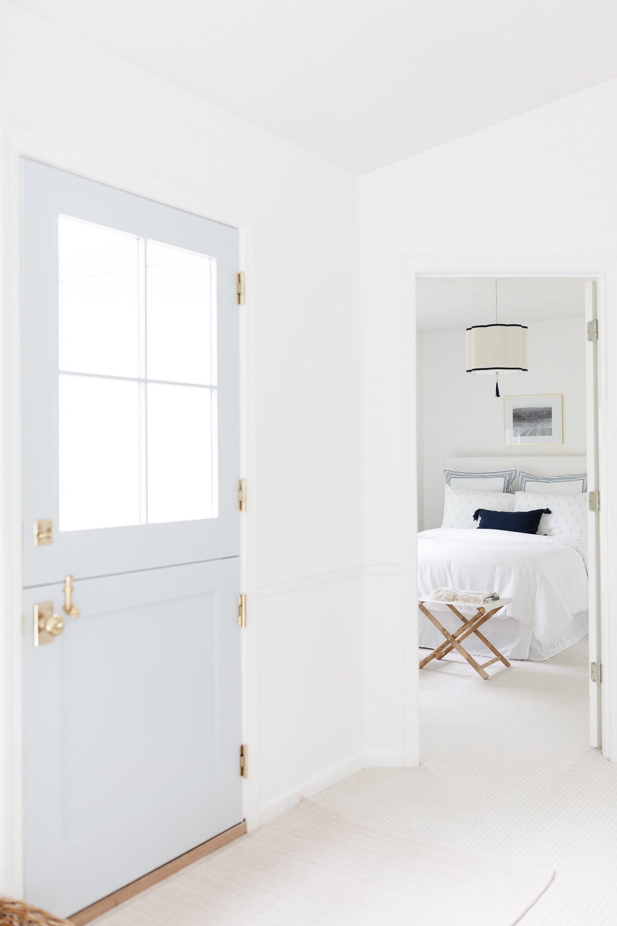 entryway with outdoor rug, stain resistant carpet and white bed