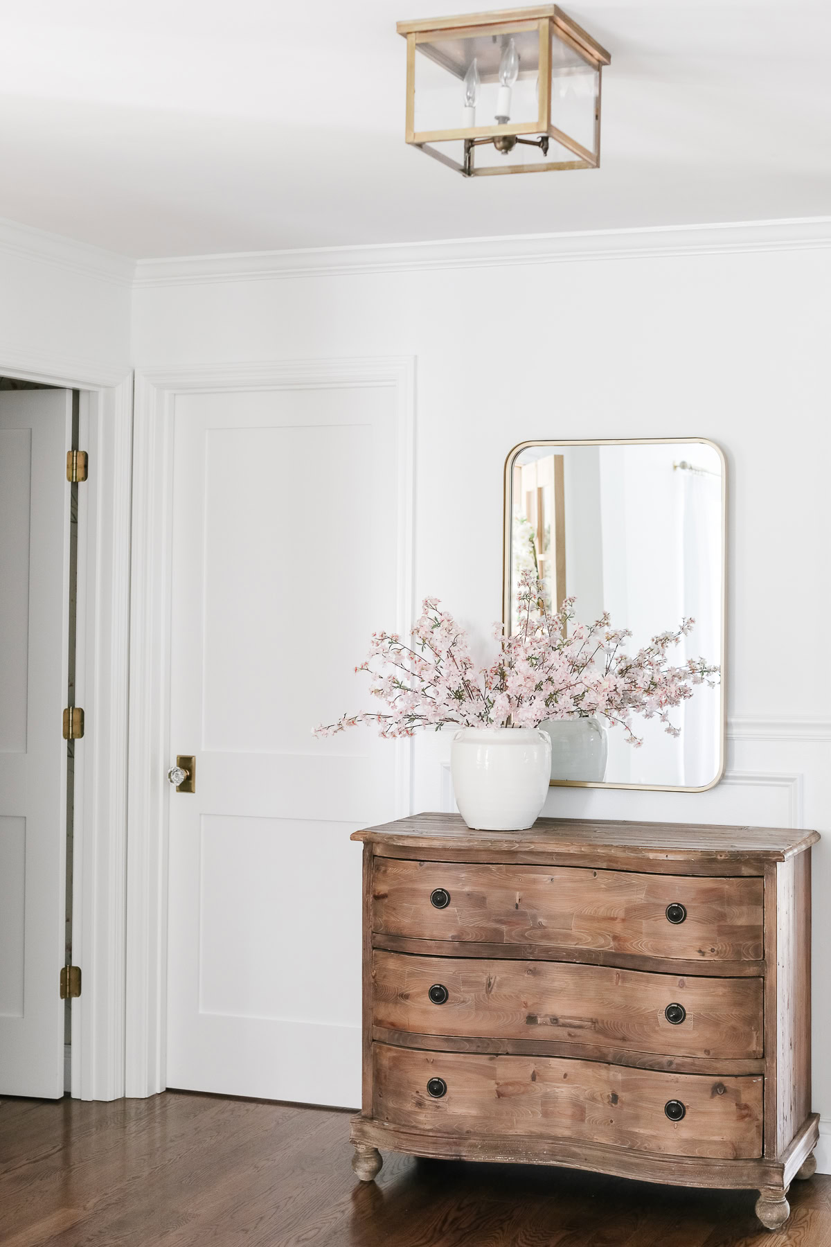 A vase of flowers on a dresser adds light to a room, bringing a touch of freshness and cheer to your space.