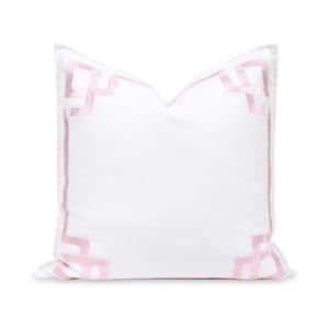 A white pillow with pink trim, perfect for adding a pop of color to any room.