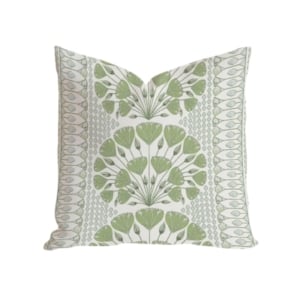 A green and white pillow with a floral pattern, perfect for adding a touch of elegance to your home decor.