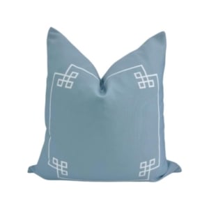 This blue pillow has a white design on it, perfect for adding a touch of style and comfort to your decor.