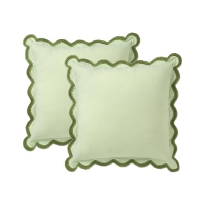 Two green scalloped pillow covers on a white background.
