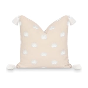 This beige pillow features white flowers and tassels, perfect for adding a touch of elegance to any room.