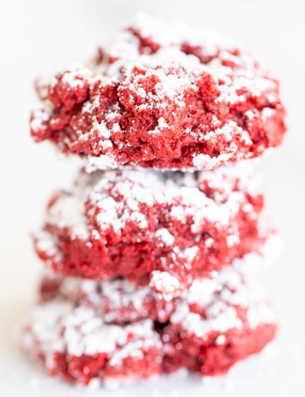 A stack of red velvet gooey butter cookies on a white surface.