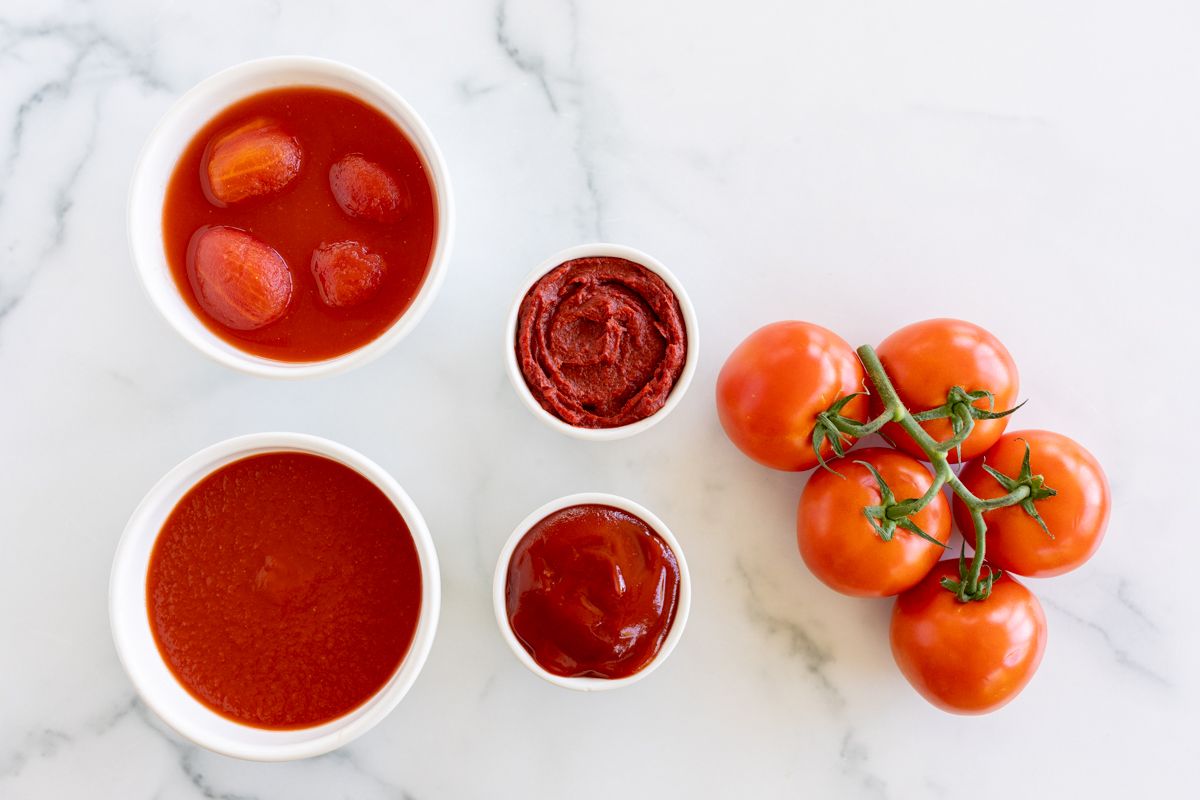 A variety of tomato paste substitutes placed on a marble countertop. 