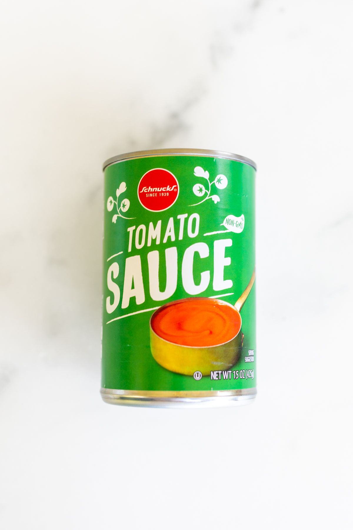A can of tomato sauce on a marble countertop.