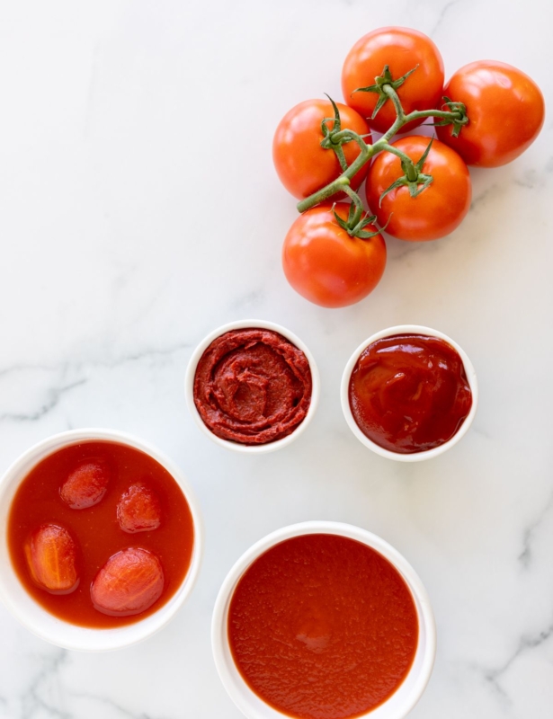 A variety of tomato paste substitutes placed on a marble countertop.