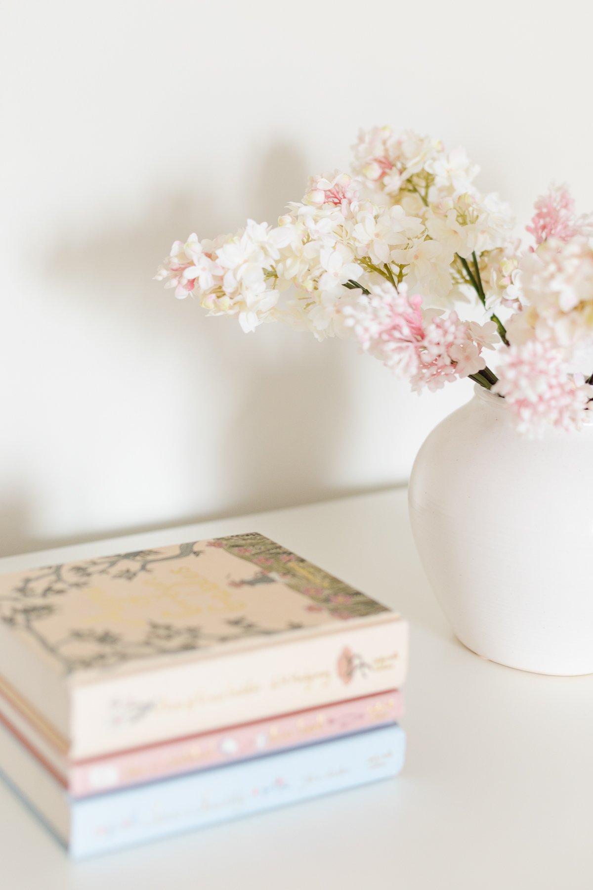 faux flowers next to stack of books