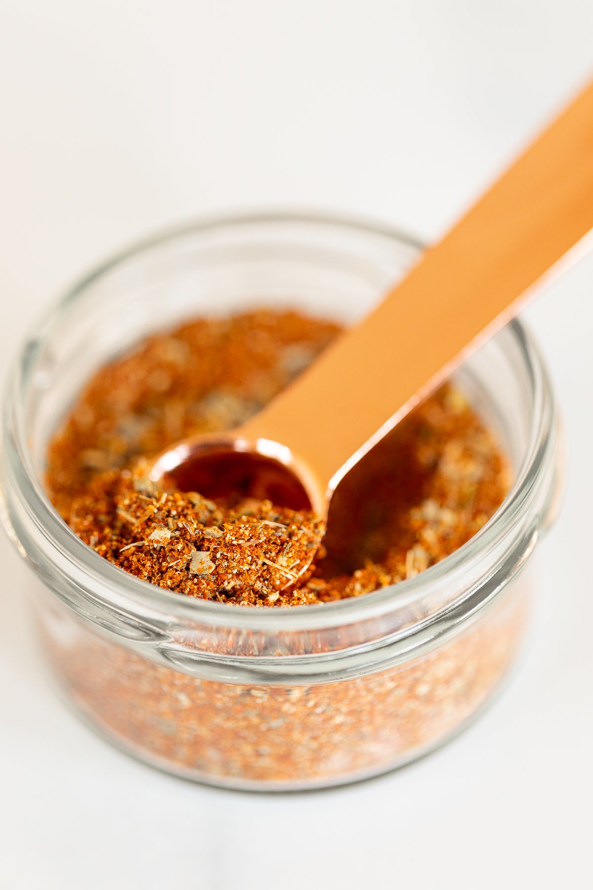 Measuring spoon scooping into jar of homemade chipotle seasoning