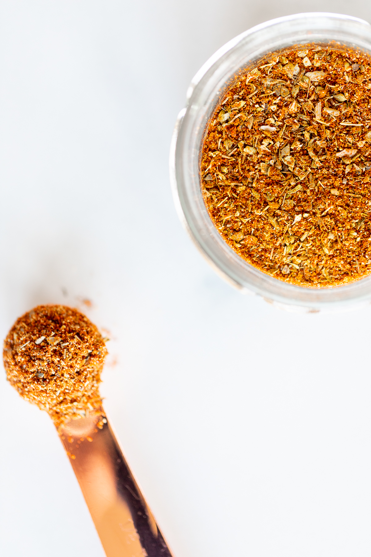 Overhead view of chipotle seasoning in jar and measuring spoon