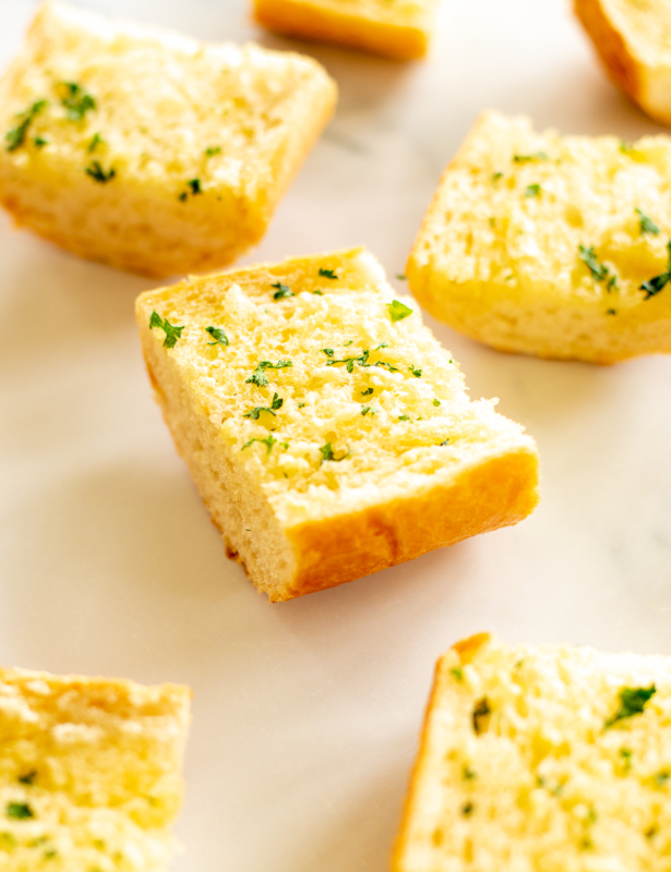 Slices of homemade garlic bread on marble countertop
