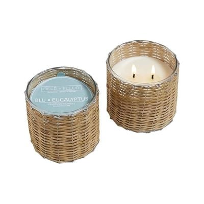 rattan candles, one is lit and one has a paper topper for packaging.