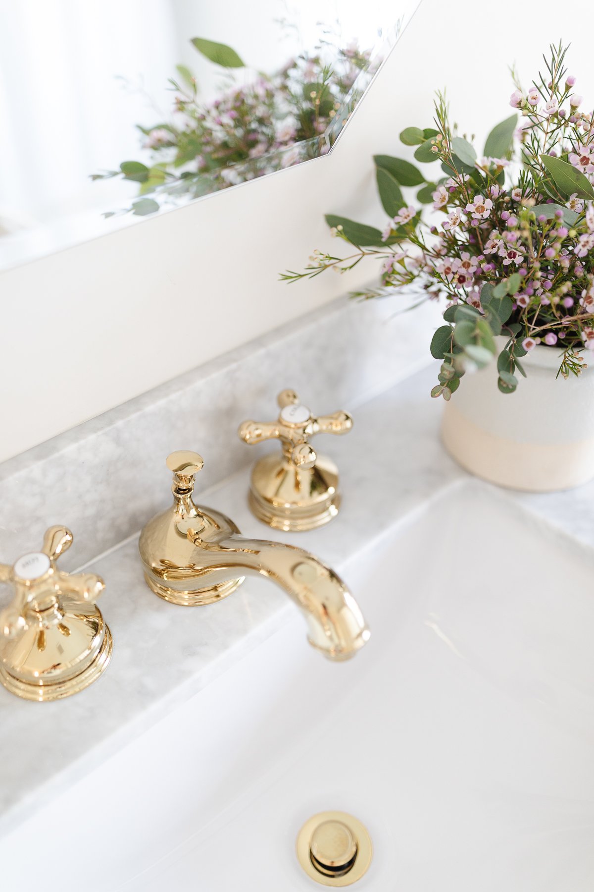 bathroom sink with flowers and brass faucet