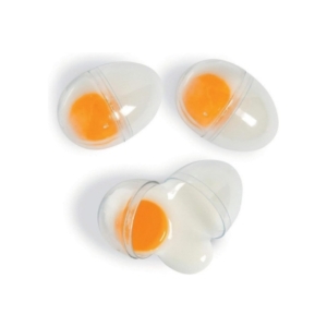 Three eggs, perfect for Easter basket fillers, in a plastic container on a white surface.