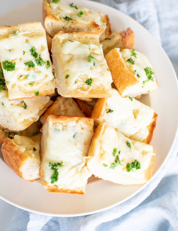 Overhead view of garlic cheese bread slices in serving bowl