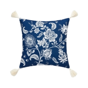 An outdoor blue and white floral pillow with tassels.