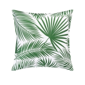 An outdoor green and white pillow with palm leaves on it.