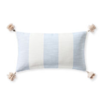 a Serena and Lily blue striped outdoor pillow with pom trim