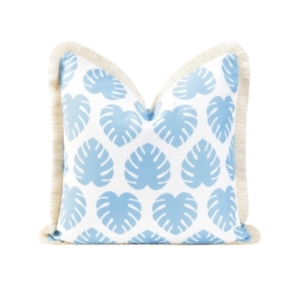 A blue and white outdoor pillow with a tassel trim.