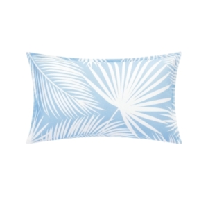 An outdoor blue and white pillow with palm leaves on it.