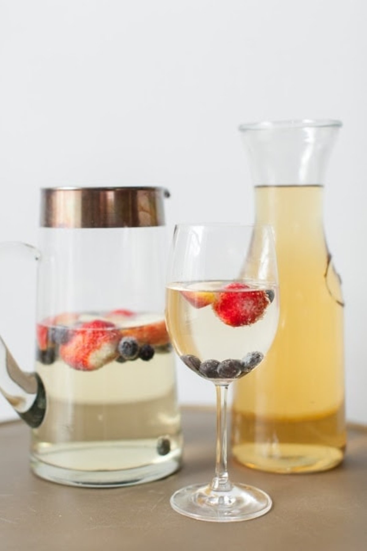 A peach champagne cocktail with fruit floating in the glass