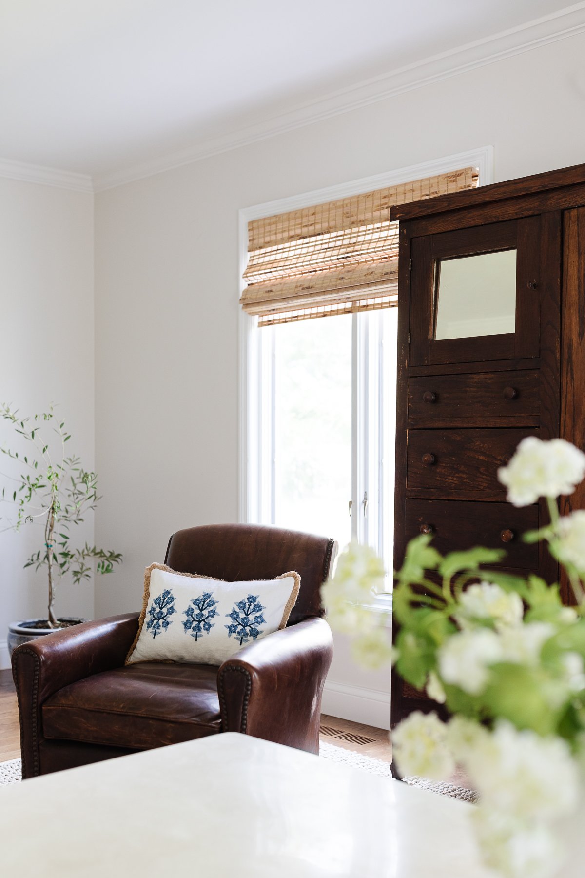 Una habitación familiar con un armario antiguo y persianas de bambú.