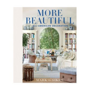 Book cover for "More Beautiful: All-American Decoration" by Mark D. Sikes, featuring a light-filled, traditionally decorated living room with bookshelves, decorative books, and blue-and-white accents.