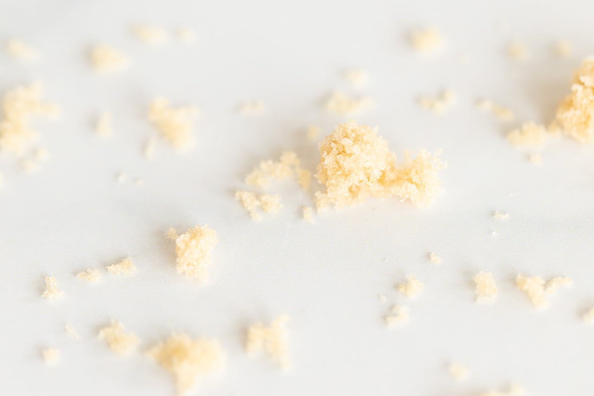Light brown sugar scattered on a white surface.