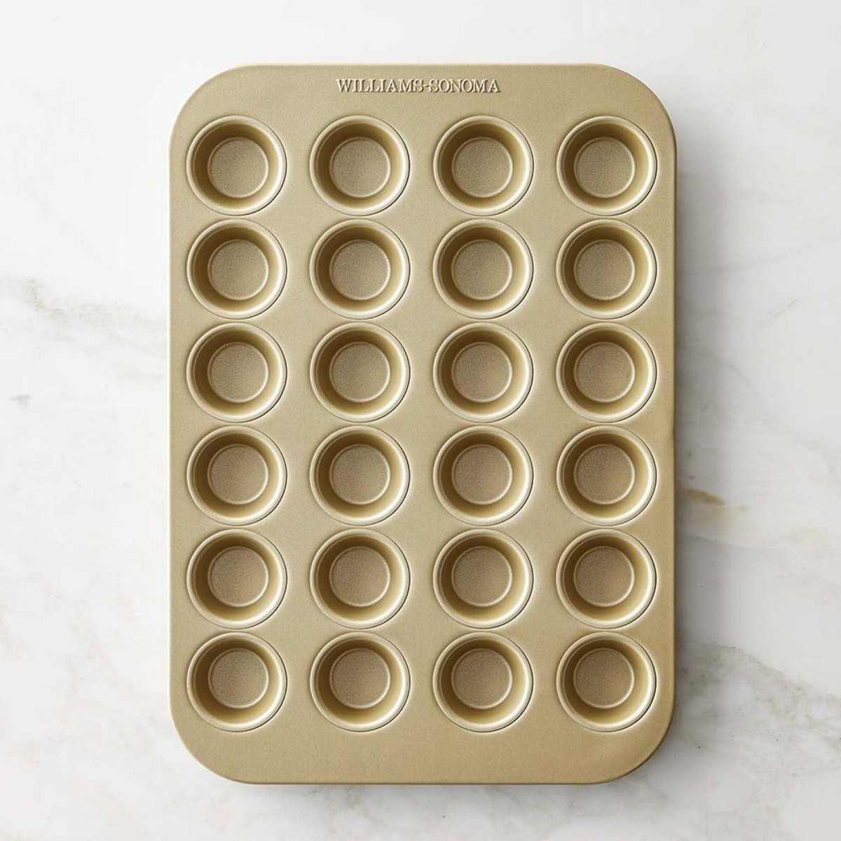 A goldtouch mini muffin pan on a marble surface