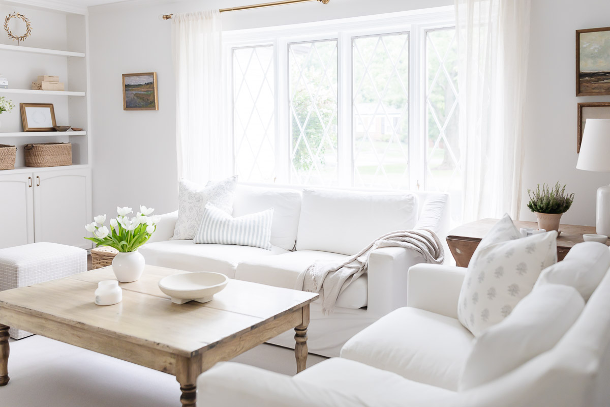 A living room with white walls, white furniture and minimalist decorating