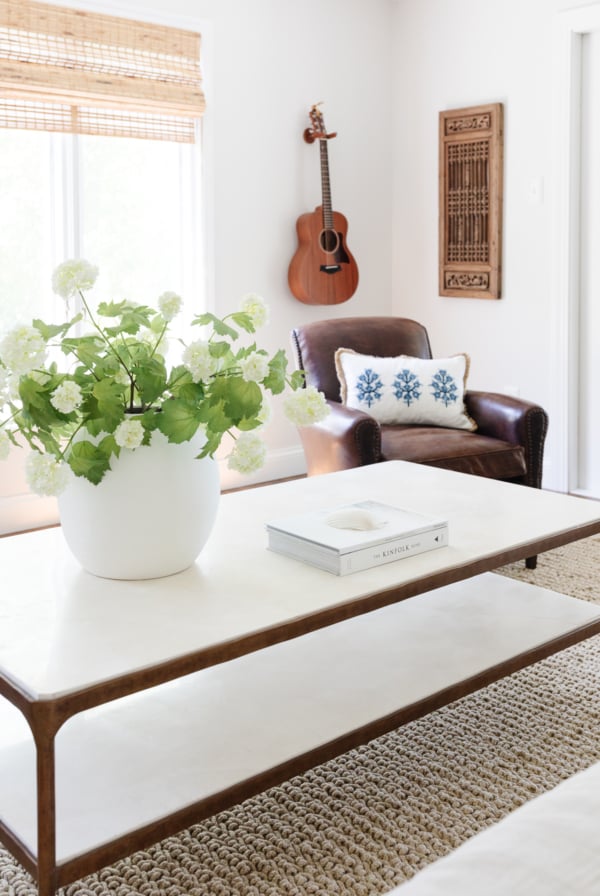 A white coffee table with a plant on it, featuring a Pottery Barn look for less.