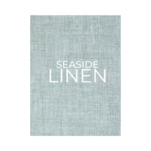 A textured light blue fabric background with the words "SEASIDE LINEN" in white capital letters centered on it, reminiscent of the cozy charm found on decorative books.