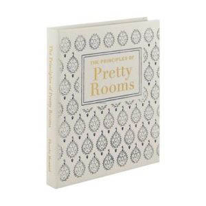 A decorative book, "The Principles of Pretty Rooms," is a hardcover edition with a cream cover featuring a repeating blue decorative pattern.