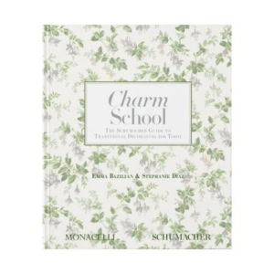 Book cover of "Charm School: The Schumacher Guide to Traditional Decorating for Today" by Emma Bazilian and Stephanie Diaz, featuring a white background with a green floral pattern—perfect for fans of decorative books.