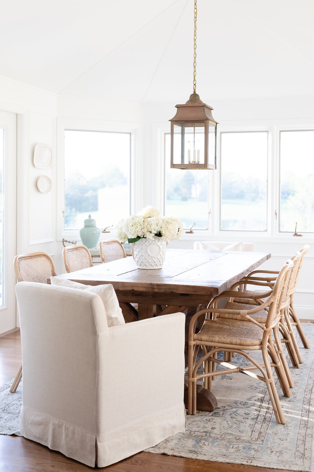 A dining room with a large table and chairs inspired by RH Look for Less.
