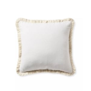 A white pillow with fringe trim, resembling Serena and Lily dupes.
