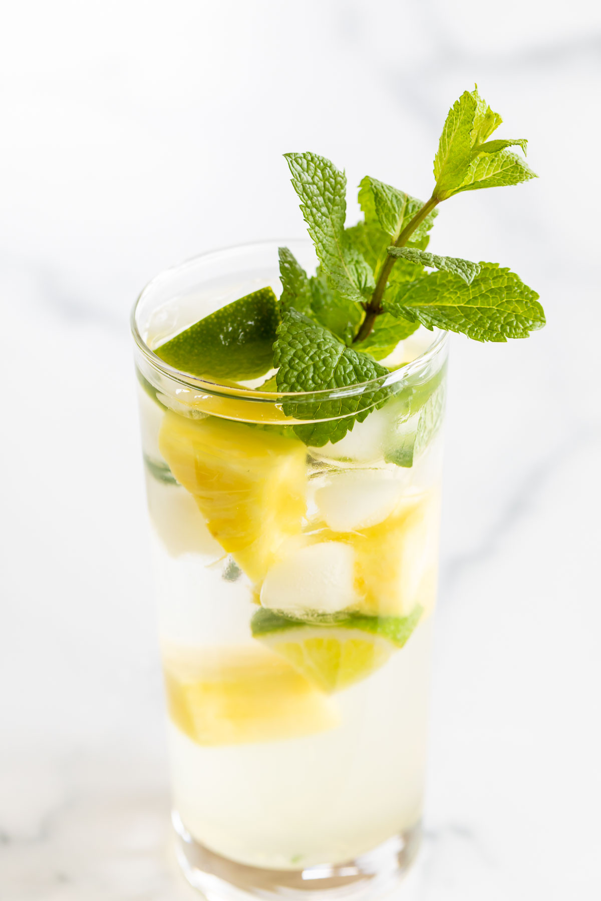 pineapple mojito in a clear glass on a marble countertop