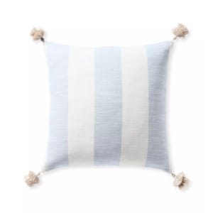 A blue and white striped pillow with tassels, offering a Serena and Lily look for less.