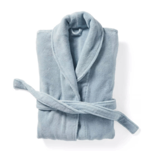 A folded light blue bathrobe with a shawl collar and a matching belt tied at the waist, perfect for adding comfort to any guest room.
